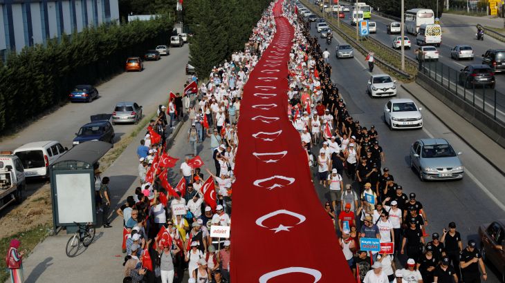 مؤيدو زعيم حزب الشعب الجمهوري المعارض الرئيسي كمال كيليتشدار مع العلم التركي العملاق في اليوم التاسع عشر للاحتجاج