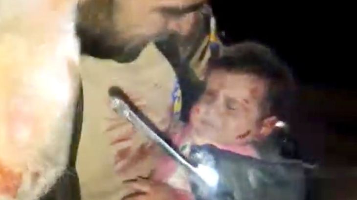 طفل جريح يحمله أحد أفراد الدفاع المدني في إدلب