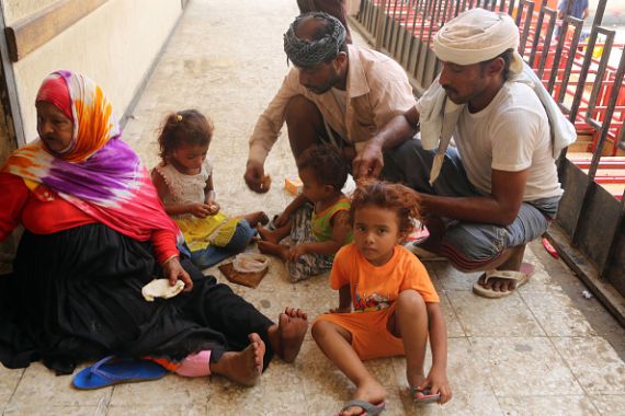 عائلة يمنية نازحة فرت من المعارك بين القوات الحكومية والمقاتلين الحوثيين بالقرب من مطار الحديدة يتشاركون وجبة 