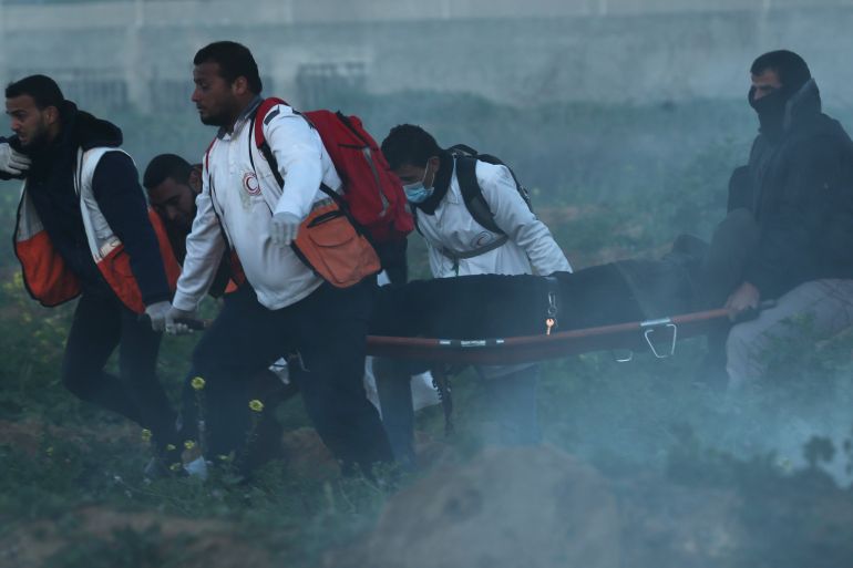 مسعفون ينقلون فلسطينيا مصابا برصاص الاحتلال خلال مسيرات العودة