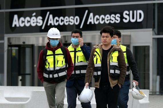 عمال يغادرون مقر مؤتمر الموبايل العالمي بعد إلغاء التجمع السنوي في برشلونة