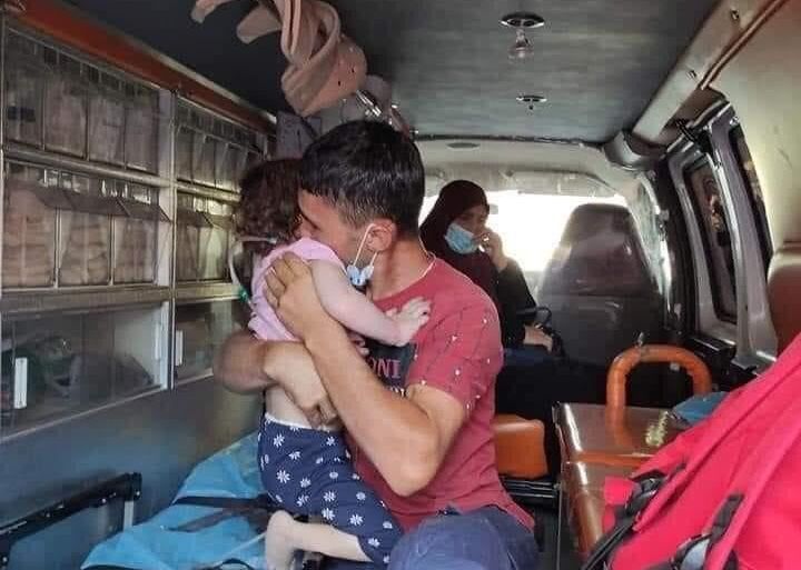 الفلسطيني عبد الله العمايرة يودع طفلته في عربة الإسعاف قبل ذهابها لمستشفى في القدس لإجراء عملية