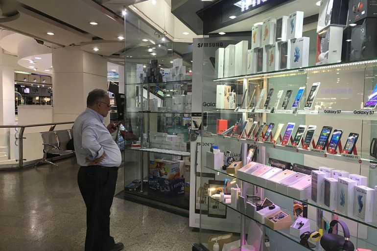 رجل يقف أمام متجر لبيع الهواتف الذكية