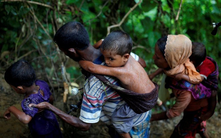 لاجئون من الروهينغيا المسلمين يتسلقون تلة بعد عبور الحدود بين بنغلاديش وميانمار
