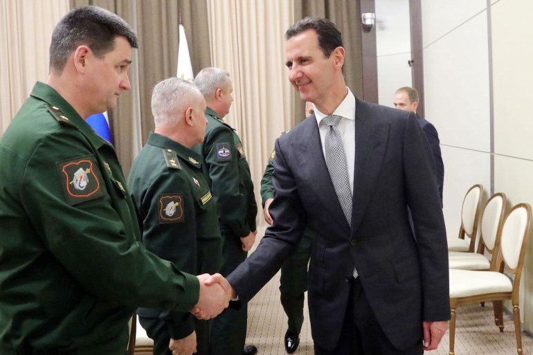 رئيس النظام السوري بشار الأسد يصافح وزير الدفاع الروسي سيرغي شويغو