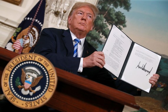 الرئيس الأمريكي دونالد ترمب يحمل مذكرة تفيد بإعادة فرض العقوبات على إيران بعد أن أعلن انسحابه من الاتفاق النووي الإيراني 