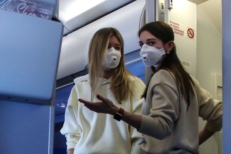 مسافرتان على متن طائرة في سويسرا تضعان كمامات خوفا من فيروس كورونا