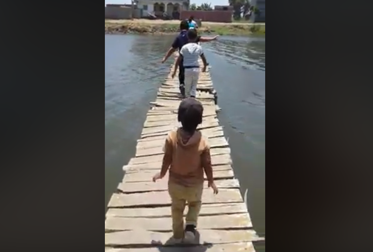 عبور أطفال على جسر خشبي آيل للسقوط في إحدى قرى مصر