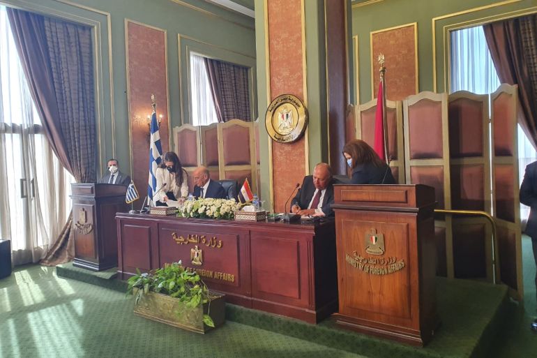 وزير الخارجية المصري سامح شكري(يمين) يزقع مع وزير الخارجية اليوناني نيكوس دندياس اتفاقية ترسيم الحدود البحرية