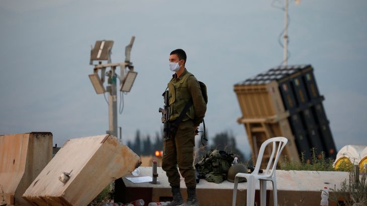 جندي إسرائيلي يقف إلى جوار القبة الحديدية