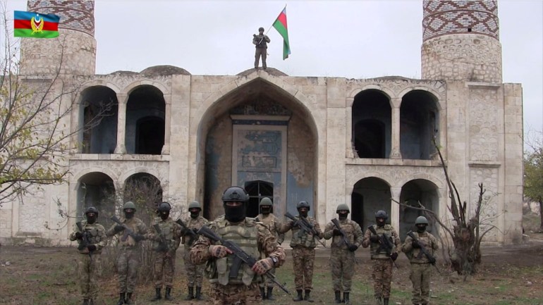 جنود أذريون يرفعون علم بلادهم على مسجد بمدينة أغدام المتاخمة لإقليم ناغورني كاراباخ