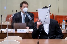 المتهم الألماني من أصول كردية محرم د. يغطي وجهه أمام الكاميرات، وخلفه محاميه ماتيوس بورن