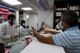 Customers buy medication inside a pharmacy in Beirut