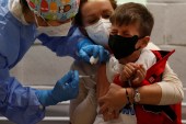 طفل إيطالي يتلقى جرعته الأولى من لقاح كورونا في روما (رويترز)