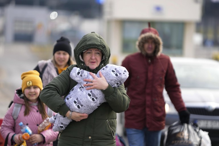 لاجئون أوكرانيون يتجهون صوب الحدود البولندية (AP)