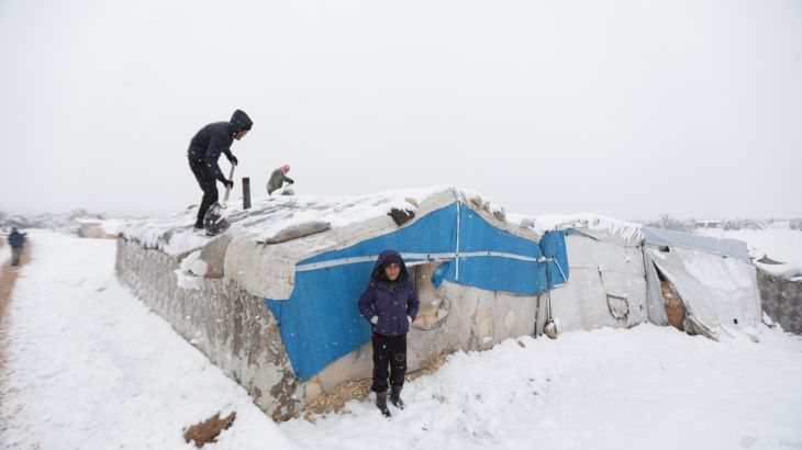 نازحون يزيلون الثلج في مخيم أعزاز بعد تساقط الثلوج في الأجزاء الشمالية من سوريا