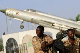 جنود في عربة عسكرية أمام مقر القيادة العامة للجيش السوداني (رويترز)