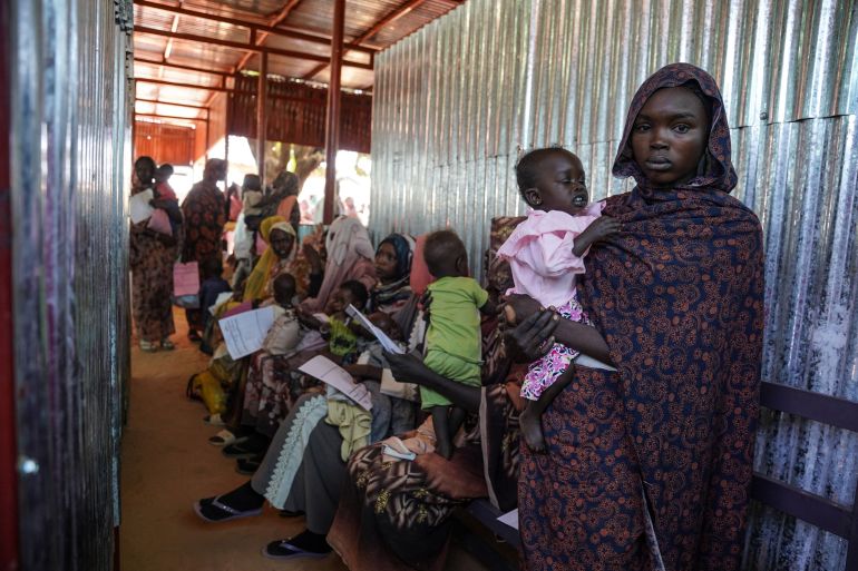 سودانية تحمل طفلها في أحد معسكرات النزوح في دارفور